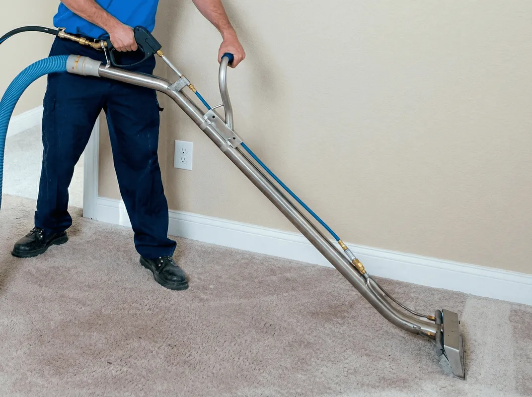 Professional operating a liquid removal machine on a carpeted floor in Denver, CO